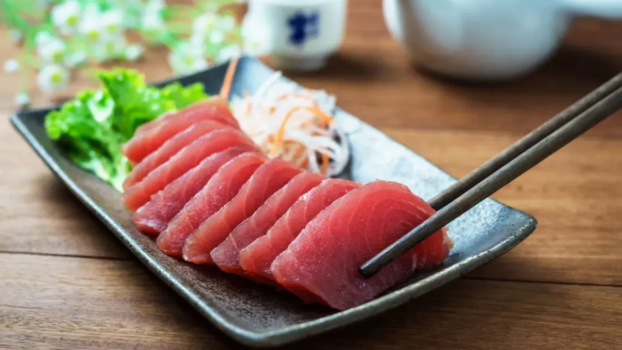 Väl förberedd tonfisk sashimi på en tallrik, redo att avnjutas med en god vin. En klassisk kombination för en lyxig måltid.