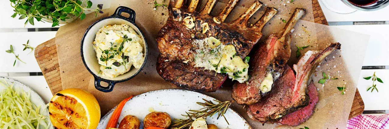 Grilla lamm med vitlök och örter, serverat med krämig potatisröra, rostade rotfrukter och grillad citron. En festmåltid!
