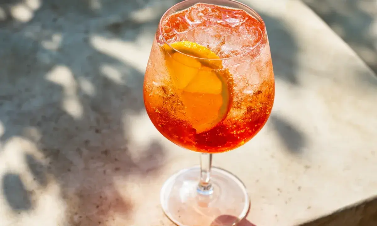Ett glas Aperol Spritz med is och apelsinskiva, perfekt för en solig dag.