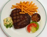 En saftig biff med pommes frites, bearnaisesås och grönsaker, en klassisk rätt från Brasserie Astoria.