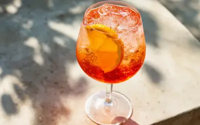 Ett glas Aperol Spritz med is och apelsinskiva, perfekt för en solig dag.