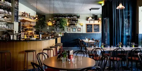 Mysig restaurang med bar, bord och stolar. Menyer på svarta tavlor ger en känsla av diket recensioner.