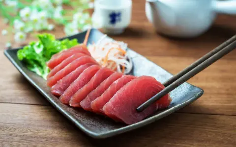 Väl förberedd tonfisk sashimi på en tallrik, redo att avnjutas med en god vin. En klassisk kombination för en lyxig måltid.
