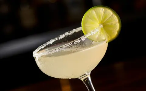 En svalkande margarita med saltkantad glaskant och en limeklyfta, redo att avnjutas mellan lakanen.