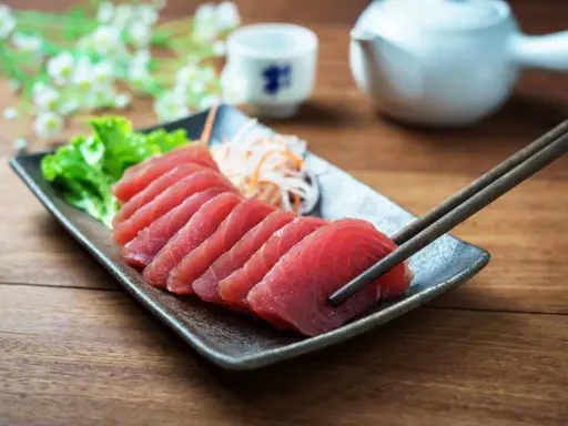 Väl förberedd tonfisk sashimi på en tallrik, redo att avnjutas med en god vin. En klassisk kombination för en lyxig måltid.