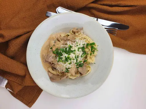 En krämig ryggbiff pasta med svamp, toppad med riven ost och persilja. En härlig middag!