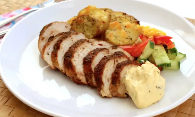 Skivad kycklingfilé i ugn, perfekt tillagad med krispiga potatisskivor, färsk sallad och en klick krämig sås.