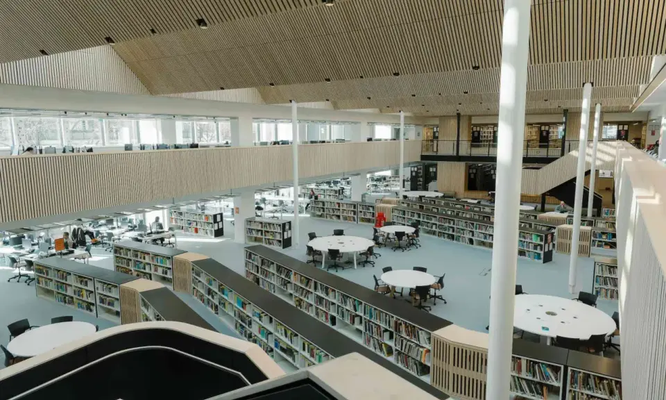 Storslagen biblioteksmiljö med bokhyllor, läsplatser och en modern arkitektur. Här kan man hitta aaltos recensioner bland tusentals böcker.