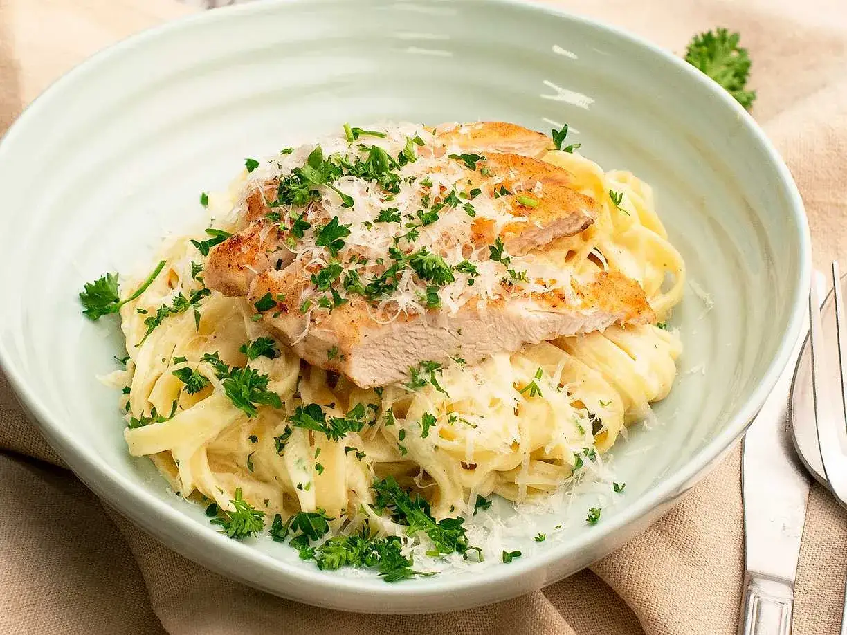En kr&auml;mig kyckling alfredo med tagliatelle, toppad med grillad kyckling, parmesan och f&auml;rsk persilja. Ett perfekt recept f&ouml;r en snabb middag.