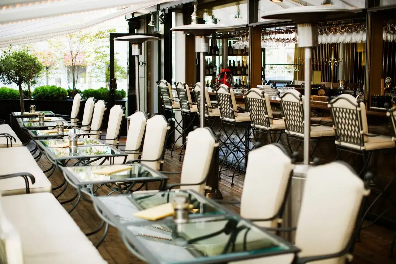 Tomma bord och barstolar på en uteservering. Perfekt för att läsa aaltos recensioner i lugn och ro.