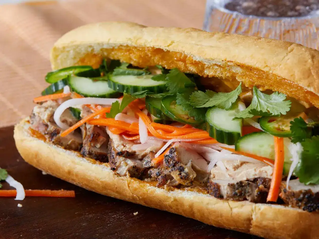 En saftig banh mi med grillat fl&auml;sk, krispig gurka, mor&ouml;tter, jalape&ntilde;os och koriander. Ett perfekt banh mi recept f&ouml;r en smakrik lunch.