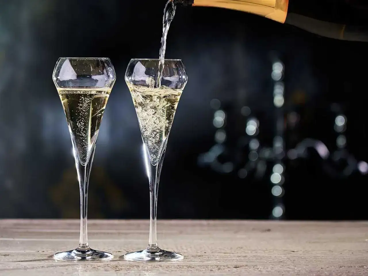 Tv&aring; glas fyllda med bubblande Pierre Olivier Blanc de Blancs Prestige Brut. En flaska h&auml;lls upp i det h&ouml;gra glaset.