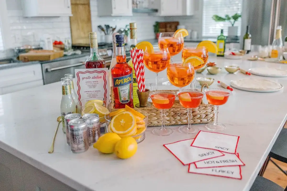 En spritz-station redo för fest med Aperol, prosecco, sodavatten, citroner, apelsiner och färdiga drinkar. Perfekt för en solig dag!