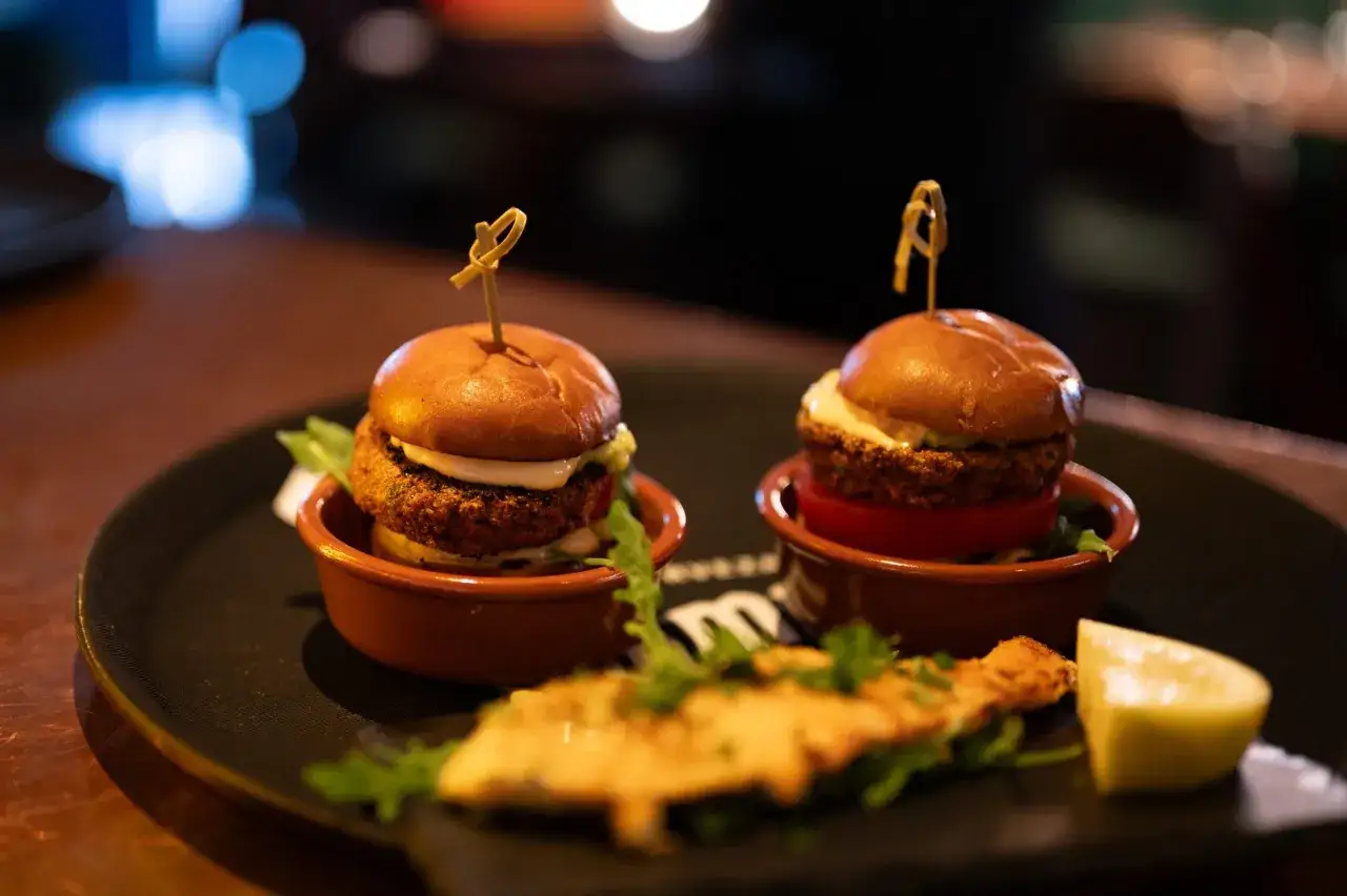 Tv&aring; sm&aring; hamburgare, presenterade med passion, som tapas. En klyfta citron och en bit friterad mat ligger framf&ouml;r.