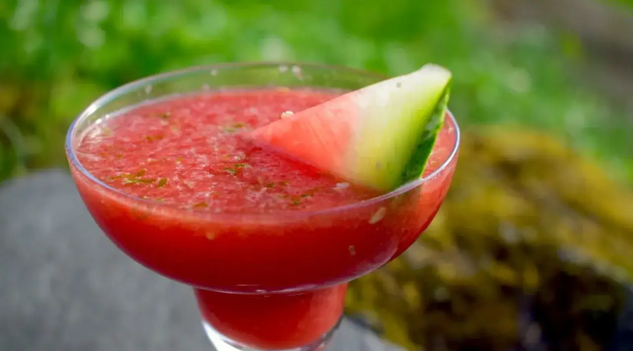 En svalkande watermelon daiquiri, garnerad med en bit vattenmelon, perfekt för en varm sommardag.