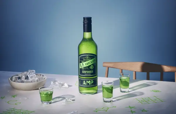 O.P. Anderson Gunpowder i gröna shotglas på ett bord med is och tic-tac-toe-ritningar.