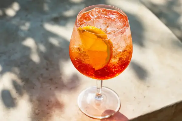 Ett glas Aperol Spritz med is och apelsinskiva, perfekt för en solig dag.